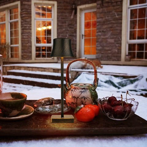 Outdoor scene with Cordless LED Desk Lamp Pack Of 2 next to teapot and fruits, showcasing copper finish and dimmable feature.