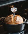 Candy Thermometer With Pot Clip, 9-Inch Long Probe inserted into bread in a pot inside an oven
