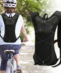 Cyclist wearing Hydration Backpack With Reflective Strips Lightweight Adjustable Nylon Reservoir for outdoor adventures.