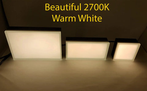 Three sizes of 2700K warm white 6x9 inch paver light in a dimly lit room, showcasing brightness and sleek design.