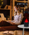 USB Powered Volcano Night Light For Kids And Adults on desk beside woman with laptop, soft LED glow with realistic lava flow.