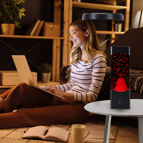 USB Powered Volcano Night Light For Kids And Adults on desk beside woman with laptop, soft LED glow with realistic lava flow.