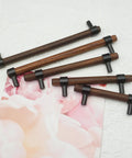 Walnut Wood Cabinet Pull Handle With Black Finish, 4.25 Inch Center To Center, 5.9 Inch Long, shown with floral print background