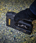 Person using Carbon Fiber Body Workhorse 2 In 1 Staple Gun Tacker for Heavy Duty Staples and 18 Gauge Brads on textured surface.