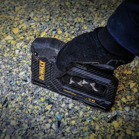 Person using Carbon Fiber Body Workhorse 2 In 1 Staple Gun Tacker for Heavy Duty Staples and 18 Gauge Brads on textured surface.
