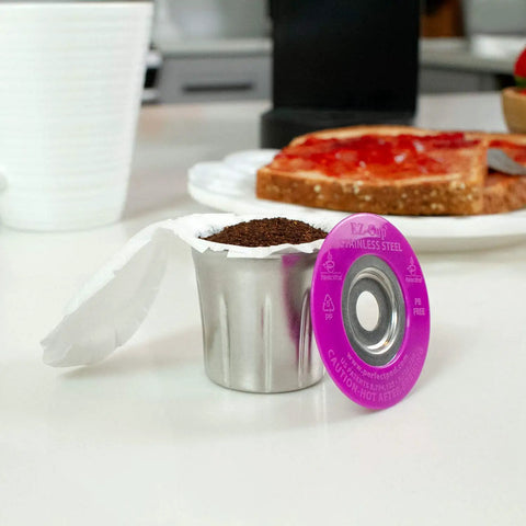 Stainless Steel Reusable K Cup For Keurig 1 Stream Coffee Pod With 25 Paper Filters on kitchen counter next to toast