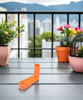 Upgrade Your Outdoor Gear With This Housoutil 2 Piece Ergonomic Hose Reel Handle Kit And Crank Knob For Quick Installation And Tidy Irrigation Pipe Storage In The Garden Or Yard. Orange hose reel handle on balcony table with potted plants