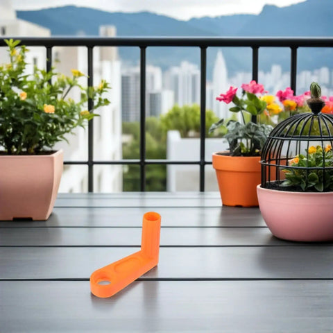 Upgrade Your Outdoor Gear With This Housoutil 2 Piece Ergonomic Hose Reel Handle Kit And Crank Knob For Quick Installation And Tidy Irrigation Pipe Storage In The Garden Or Yard. Orange hose reel handle on balcony table with potted plants