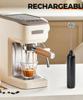 Rechargeable Handheld Milk Frother With USB Type C 3 Speed Adjustable Foam Maker next to an espresso machine