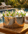 Armored XL Insulated Beverage Tub For Parties, Double Wall Stainless Steel Ice Bucket holding beer bottles by poolside