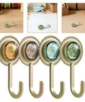 Slick Four Pack Adhesive Wall Hooks For Hanging Towels And Robes With Knockout Grip No Drilling Required Super Quick Mount For Bathroom Kitchen Or Entryway Storage, featuring colorful jewels.