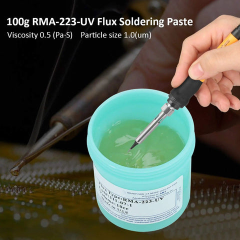 Hand using soldering iron with RMA-223-UV Solder Flux Paste For CSP BGA PCBs, 100g container, showcasing flux viscosity and particle size.