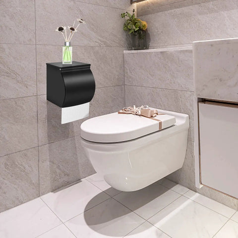 Matte black self adhesive toilet paper holder mounted on bathroom wall, next to modern toilet. SUS 304 stainless steel construction.