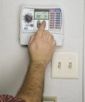 Person adjusting Indoor Sprinkler Timer For Six Zones With Easy Set Controller No Fuss Programming And One Touch Seasonal Adjust