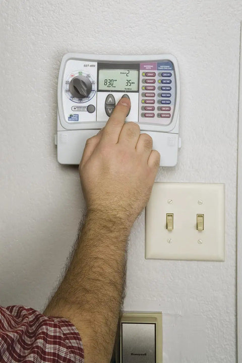 Person adjusting Indoor Sprinkler Timer For Six Zones With Easy Set Controller No Fuss Programming And One Touch Seasonal Adjust
