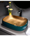 Premium Porcelain Vessel Sink For Above Counter Bathroom Vanity Zero Hassle Cleaning Scratch Resistant Glaze Smooth Finish Compact Art Basin with gold interior and teal exterior.