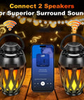 Flame Lamp Speaker With Multicolor Lights For Outdoors Patio Pool Camping Waterproof Torch Lantern 7 Lighting Modes And Music Sync RGB Glow For A Dope Vibe Lit Ambience And Great Gift For Men Him Dad on table with phone