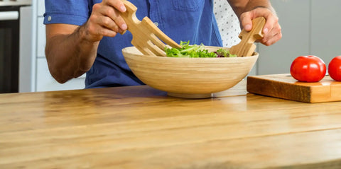 Person using salad utensils in a wooden bowl on a butcher block table, related to Butcher Block Conditioner With Food Grade Mineral Oil For Wood Cutting Boards And Spoons 12 Fl Oz Beeswax And Carnauba Wax Finish Keeps It Water Resistant For Salad Bowls Wooden Toys And More
