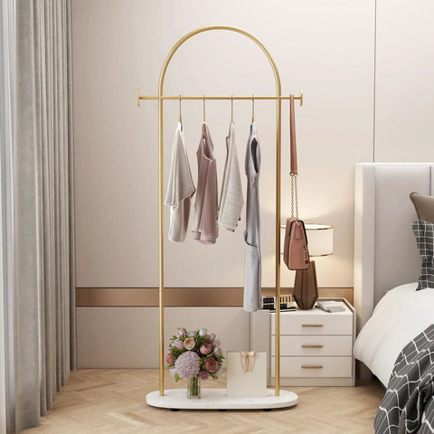 Gold Clothing Rack With Shelf, Heavy Duty Freestanding Coat Rack, Metal Hanger Stand With Hooks For Boutique Office, Space Saving 23.6 Long By 13 Wide By 67 Tall, Sturdy And Durable Metal Construction, displayed in cozy bedroom setting.