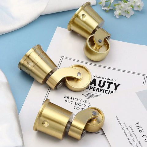 Vintage Solid Brass Casters 4 Piece Set Antique Swivel Furniture Wheels 27 mm displayed on a flat surface with papers.