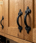 Old School Medieval Rustic Cast Iron Door Pull With Fleur De Lis Handle And Compact Grip, 7 1/8 Inch Decorative Hardware installed on wooden cabinet