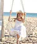 Woman sitting in a Cozy Hammock Chair Set Of 2 Macrame Swing Chairs With Tassels Bohemian Style Handwoven Cotton Rope Indoor Outdoor Beige