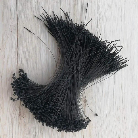 No Fancy Tools Needed Five Inch Black Plastic Hang Tag Fasteners One Thousand Pack shown in a pile, ideal for clothing and accessories.