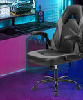Ergonomic Gaming Desk Chair With PU Leather Upholstery in home office setup, showing flip-up armrests and height adjustable base.