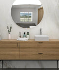 White Ceramic Square Vessel Bathroom Sink on wooden vanity with round mirror in modern bathroom setting.