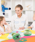 Teacher with students using Circle Punch Set for crafting. Circle punch tools in 3 inches, 2 in, 1.5 in, and 1 in sizes on table.