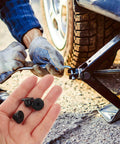 Hand holding 5 Piece Rubber Hydraulic Filler Plugs Set For 5 Sixteen Inch Holes Floor Oil Filler Bung And Automotive Jack Accessory