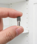 Hand holding one of 150 Pcs Stainless Steel Shelf Pins 5mm Invisible Mount For Wood And Glass Shelves Sleek Stable Support For Cabinets 