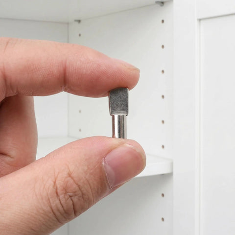 Close-up of hand holding a stainless steel shelf pin from the Stainless Steel Shelf Pins 150pcs 5mm Silver Cabinet Shelf Pegs.