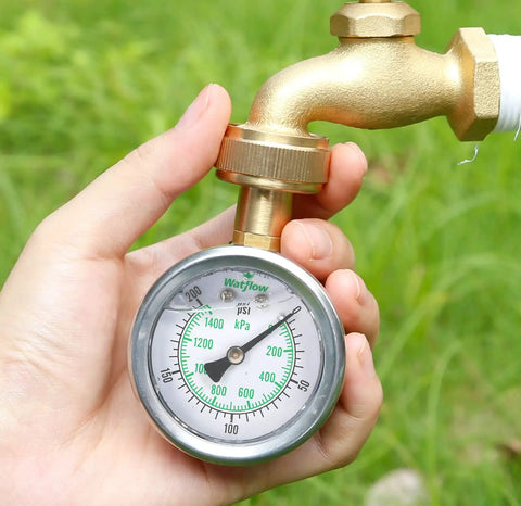 Person holding a 2 Inch Glycerin Filled Stainless Steel Water Pressure Gauge Built For Home And Garden Use, connected to a hose.