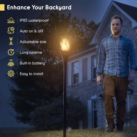 Man walking near Solar Torch Light With Realistic Flickering Flame, Waterproof Outdoor Tiki Torches With 96 LED Bulbs Creating A Realistic Fire Look, No Wires Needed, Easy Setup, Durable Outdoor Lighting, 4 Pack.