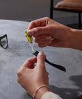 Heavy Duty Super Glue Fine Tip for Home Office Quick Fixes, applying on a black watch strap for repair.