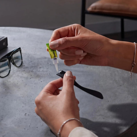 Heavy Duty Super Glue Fine Tip for Home Office Quick Fixes, applying on a black watch strap for repair.