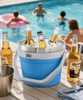 Rock Solid 7 Liter Insulated Ice Bucket With Handy Bottle Opener Double Wall Vacuum Stainless Steel Drink Cooler Holds Six Longnecks Or Three Wine Bottles For Backyard Bashes And Chill Gatherings Blue filled with ice and bottles, poolside setting.