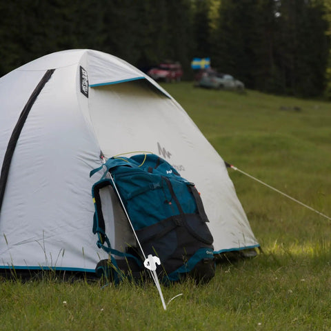 Camping scene with Heavy Duty Tent Stakes and Pegs Kit with Windproof Ropes and Hammer Storage Bag securing a tent