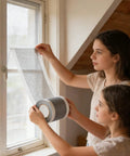 Two people installing Cuttable Window Screen Repair Tape For Holes And Tears on a window screen in a home.