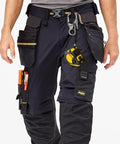 Person wearing utility pants with tools, highlighting Rugged 3 Inch Carabiner Keychain Clip With Dual Locking Design And Tungsten Steel Spike.