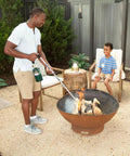 Man using Self Igniting Outdoor Torch, 20,000 BTU High Output Flame, 36 Inch Handle on firewood in outdoor fire pit