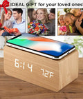Dope Wooden Digital Alarm Clock With Qi Wireless Charging Pad For iPhone Samsung Featuring Smart Clap Activated Wake Light Plus Room Temperature Tracker on nightstand with phone.