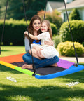 Mother and daughter on 9.5 Foot Tall Swing Set For Backyard Setup With Platform Swing And Trapeze Bar Heavy Duty Metal Frame Green And Brown Outdoor Playground For Kids And Adults Supports Up To 600 Lbs In A Sturdy A Frame.