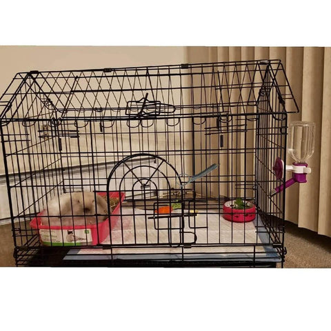 Front view of metal rabbit cage with spring latch door, pink base tray, water bottle, and a rabbit inside
