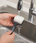 Person rinsing a foam roller from the 6 Piece Foam Sponge Roller And Brush Set Hella Smooth Kids Painting Tools.