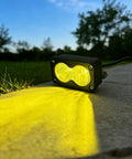 Ultra Bright 20W 6500K Baja Style LED Headlight Bar casting yellow light outdoors, showcasing IP68 waterproof, rugged design.
