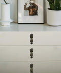 White dresser with Antique Brass Drop Pull Handles 4 Pack Featuring Ornate Pendant Drawer Knobs With European Scrollwork Base.