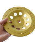 Hand holding a 7 Inch Double Row PCD Cup Wheel Set For Beastly Concrete Coatings Removal And Surface Prep Remove Epoxy Mastic Glue Stucco Thinset
