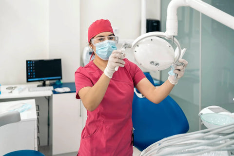 Professional wearing 12 Pack Safety Glasses Over Eyeglasses With Anti Fog And Scratch Resistant ANSI Z87 Protective Eyewear, in a dental clinic.